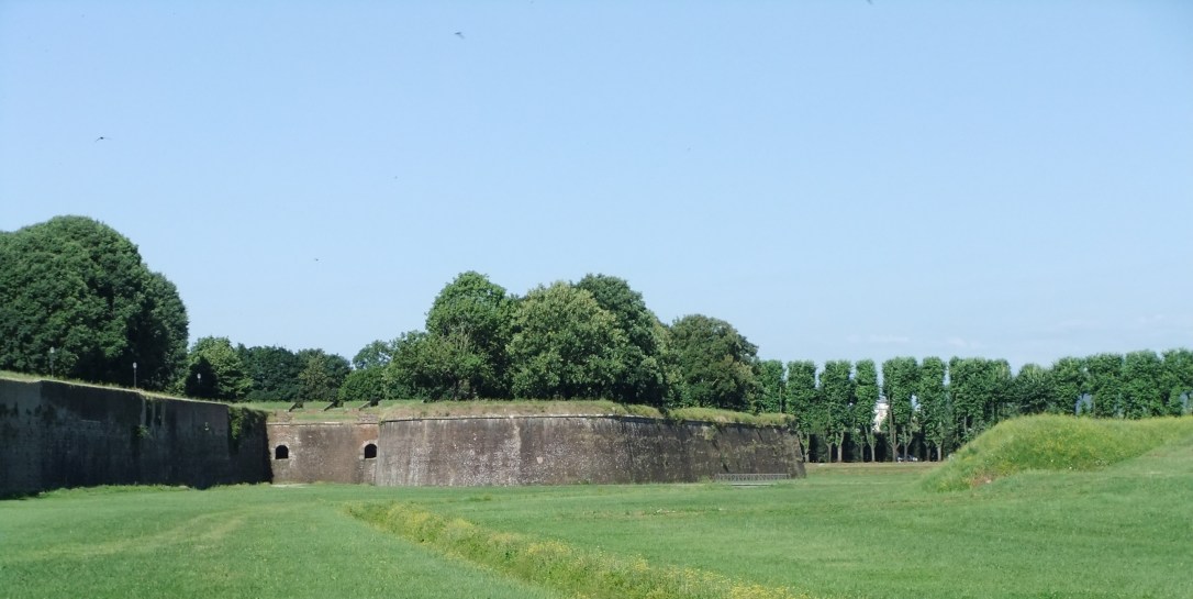 Wide open mowed lawns stretch out below the exterior city walls.